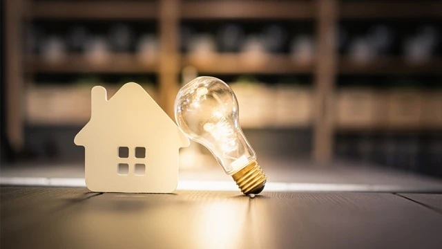 light bulb wood house on table